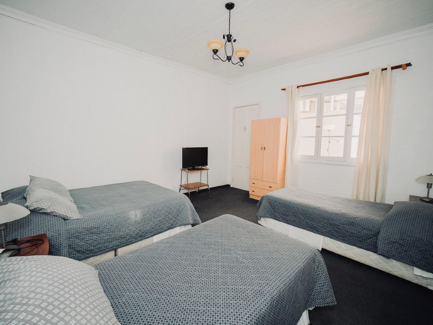 Habitación cuádruple del hotel con varias camas y ventana alta