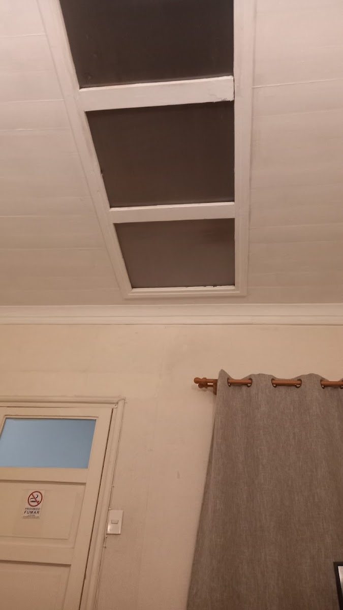 Cielo alto de la casona con ventanas interiores de madera sobre el tabique