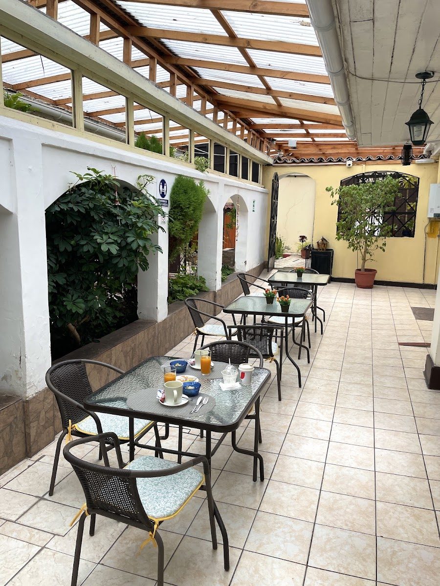 Mesas de desayuno servidas en el patio techado del hotel